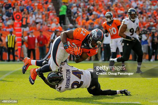 Running back C.J. Anderson of the Denver Broncos is tackled by defensive back Kyle Arrington of the Baltimore Ravens in the third quarter of a game...