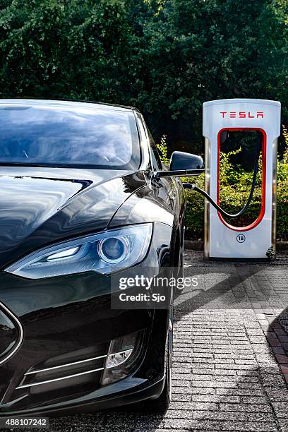 tesla model s electric car at a supercharger charging station - tesla model s stock pictures, royalty-free photos & images