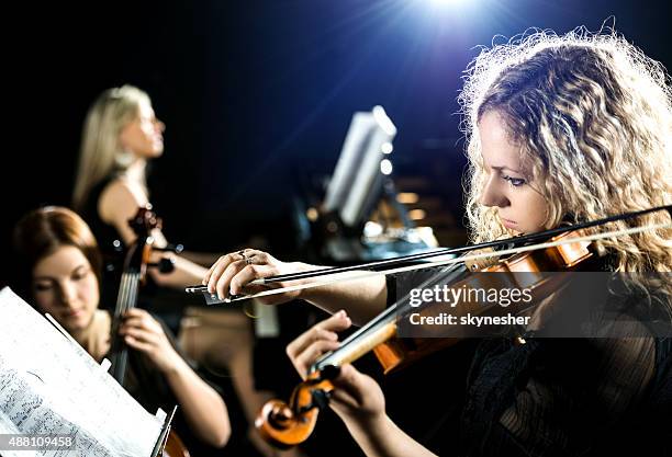 serious woman playing the violin. - classical music stock pictures, royalty-free photos & images
