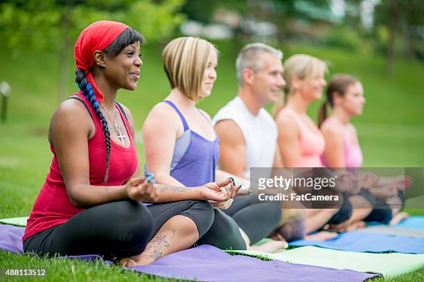 adult yoga class - moving up to seated position stock pictures, royalty-free photos & images