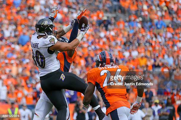 Tight end Crockett Gillmore of the Baltimore Ravens goes up for a catch in the end zone and is defended by strong safety David Bruton and defensive...