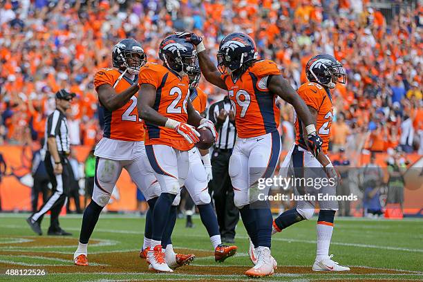 Defensive back Darian Stewart of the Denver Broncos celebrates with Danny Trevathan and Aqib Talib after making a game-ending interception in the...