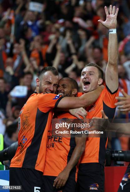 Henrique of the Roar celebrates with Ivan Franjic and Besart Berisha after he scored in extra time during the 2014 A-League Grand Final match between...