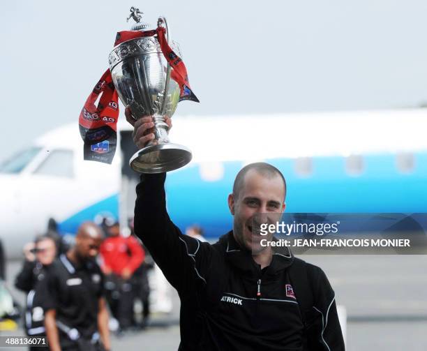 Guingamp's French midfielder and captain Lionel Mathis presents the trophy to supporters upon the team's arrival from Paris at Tremuson's airport,...