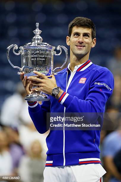 Novak Djokovic of Serbia celebrates with the winner's trophy after defeating Roger Federer of Switzerland during their Men's Singles Final match on...