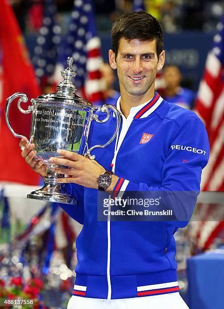 Novak Djokovic of Serbia celebrates with the winner's trophy after defeating Roger Federer of Switzerland during their Men's Singles Final match on...