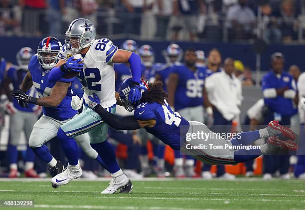 Jason Witten of the Dallas Cowboys carries the ball against Jasper Brinkley of the New York Giants and Uani' Unga of the New York Giants in the...