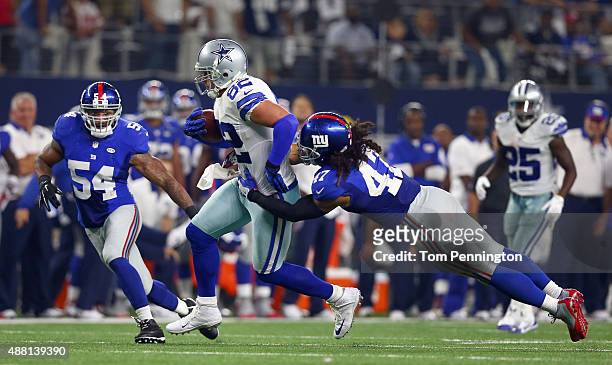 Jason Witten of the Dallas Cowboys carries the ball against Jasper Brinkley of the New York Giants and Uani' Unga of the New York Giants in the...