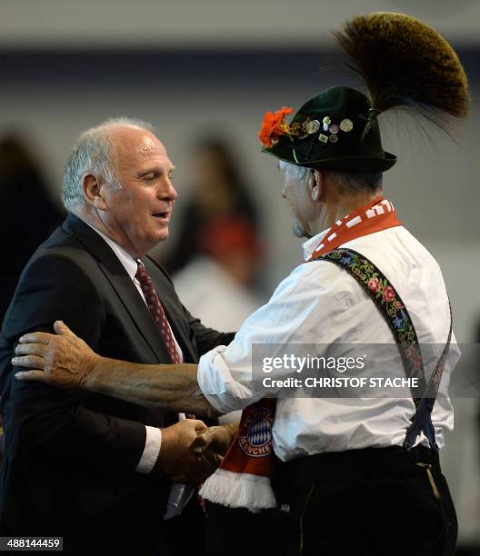 Former Bayern Munich's President Uli Hoeness shakes hands with a participant, dressed in typical Bavarian clothes, during the annual general meeting...