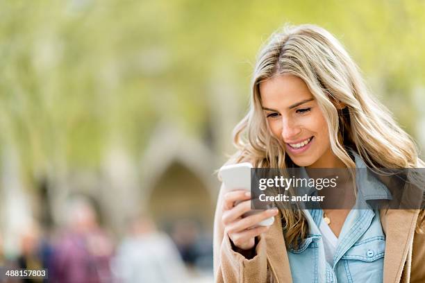 woman texting on the phone - blonde hair woman city stock pictures, royalty-free photos & images