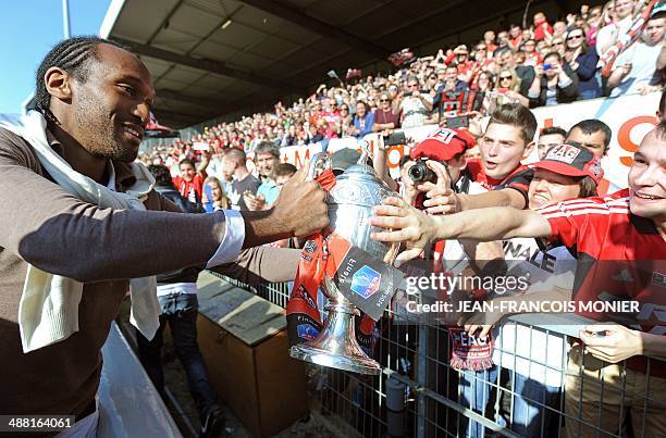 Guingamp's French defender Jeremy Sorbon raises and presents the Coupe de France trophy to supporters during a celebration ceremony at the Roudourou...