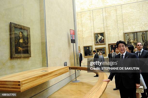 Japanese Prime Minister Shinzo Abe stands near "La Joconde", a 1503-1506 oil on wood portrait of Mona Lisa by Leonardo Da Vinci, at the Louvre Museum...