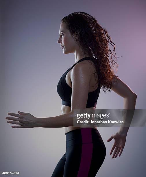 athletic, sweaty female running, side view - forward athlete stock pictures, royalty-free photos & images