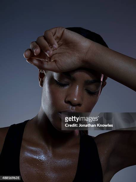 dark skinned female, wiping off sweat of forehead - 人体部位 ストックフォトと画像