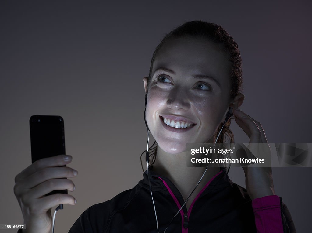 Sporty female with her mobile, smiling