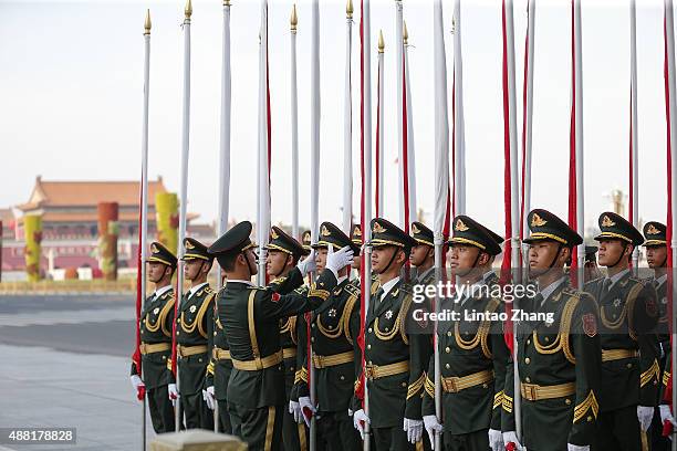 Chinese honor guards adjust their attire before a welcome ceremony for Mauritania's President Mohamed Ould Abdel Aziz at the Great Hall of the People...