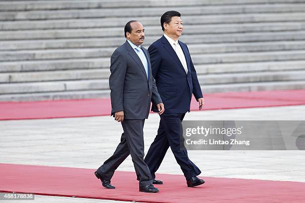 Chinese President Xi Jinping accompanies Mauritania's President Mohamed Ould Abdel Aziz to view an honour guard during a welcoming ceremony outside...