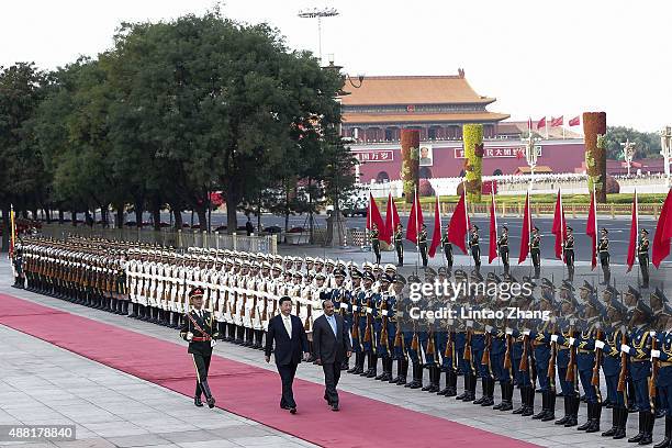 Chinese President Xi Jinping accompanies Mauritania's President Mohamed Ould Abdel Aziz to view an honour guard during a welcoming ceremony outside...