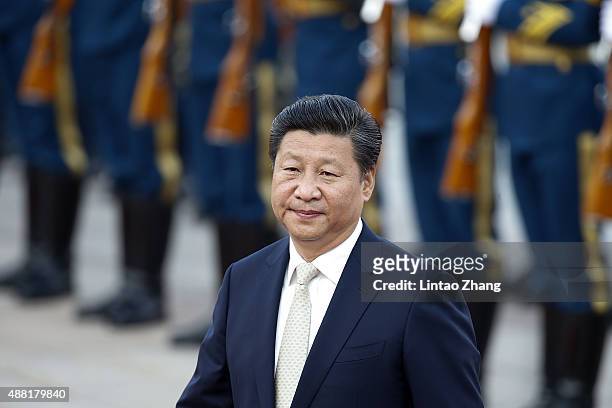 Chinese President Xi Jinping accompanies Mauritania's President Mohamed Ould Abdel Aziz to view an honour guard during a welcoming ceremony outside...