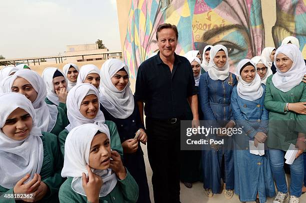 British Prime Minister David Cameron meets pupils at the Safiyyeh Bint Abdel Muttaleb Girls School in the town of Zaatari, which receives funding...