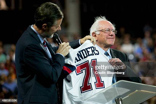 Senator Bernie Sanders, an independent from Vermont and 2016 Democratic presidential candidate, right, receives a Liberty University jersey from...