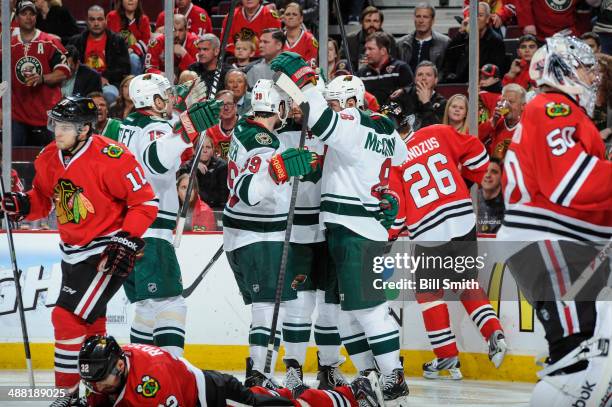 Cody McCormick of the Minnesota Wild celebrates with teammates Dany Heatley and Nate Prosser after scoring in the third period, as Jeremy Morin of...