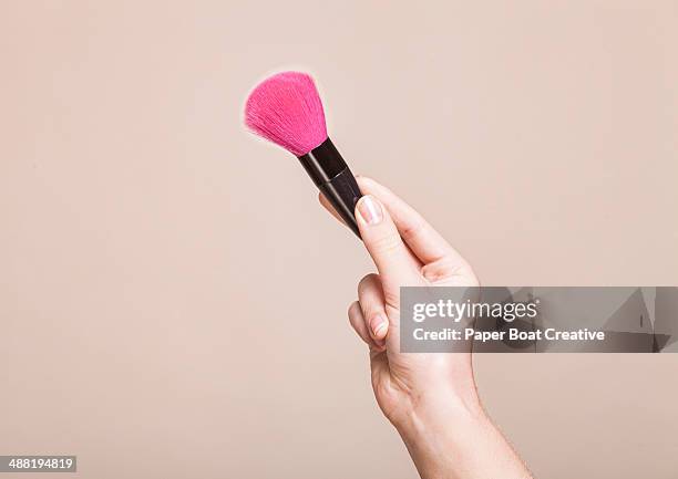 close up of a hand holding a blush brush - make up brush stock pictures, royalty-free photos & images