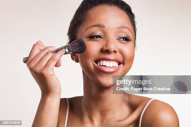 lady laughing while applying blush brush on cheeks - blusher make up photos et images de collection