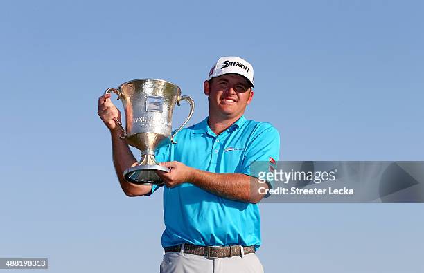 Holmes celebrates with the trophy after winning the Wells Fargo Championship in the final round on May 4, 2014 in Charlotte, North Carolina.