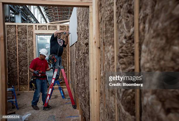 Workers attach drywall to the inside of a house being constructed at the BLU Homes Inc. Production facility in Vallejo, California, U.S., on Friday,...