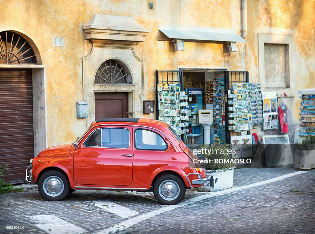 Vermelho Fiat 500 estacionado na frente de loja de lembrança.