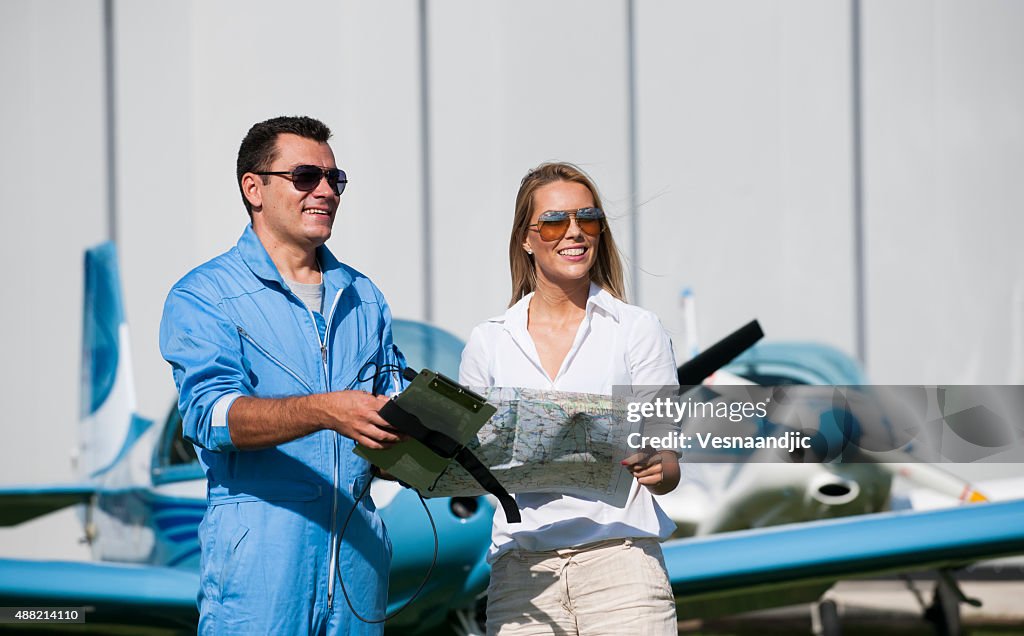 Woman And Man Pilot Looking At Map Preparing For Flying High-Res Stock ...