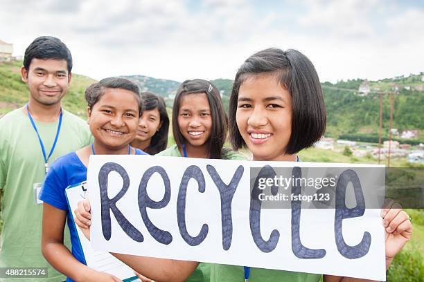 multi-ethnic group of teenagers hold "recycle" sign outdoors. - world earth day in india stock pictures, royalty-free photos & images