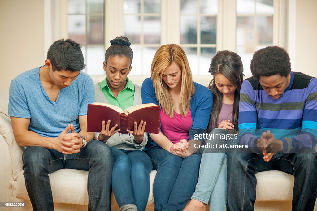Adolescents Praying sur Bible d'étude
