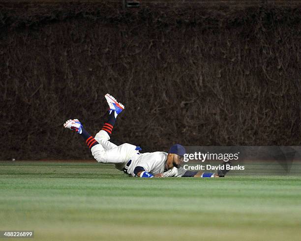 Emilio Bonifacio of the Chicago Cubs makes a catch on Mark Ellis of the St. Louis Cardinals during the seventh inning on May 4, 2014 at Wrigley Field...