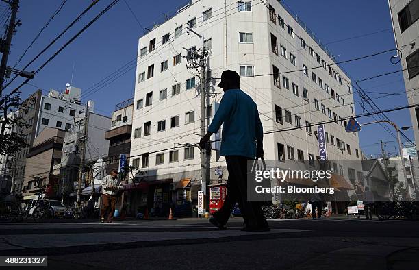 Man walks through the Airin area of Nishinari ward in Osaka, Japan, on Friday, May 2, 2014. Osaka prefecture's economic output dropped 6.2 percent to...