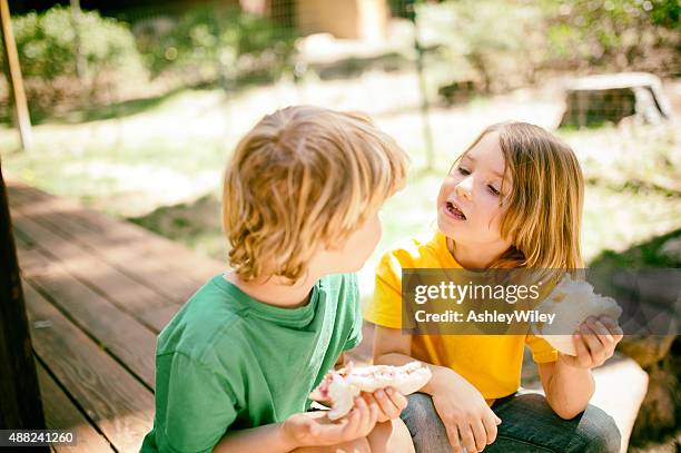 kinder genießen sie ein mittagessen - girls laughing eating sandwich stock-fotos und bilder