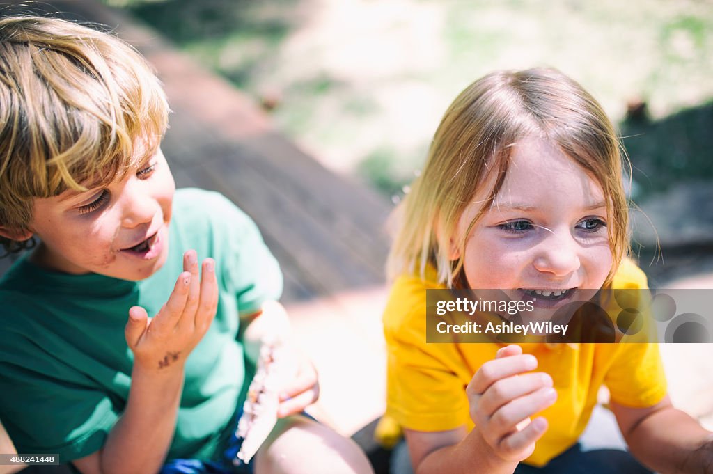Two children laugh eating lunch