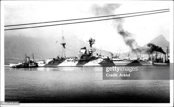 British Royal Navy Battleship HMS Royal Sovereign, in dazzle camouflage anchoring in an undisclosed naval port, ca. 1940.