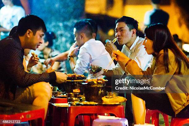 young vietnamese people enjoying barbecue on hanoi street late night - vietnam spring stock pictures, royalty-free photos & images