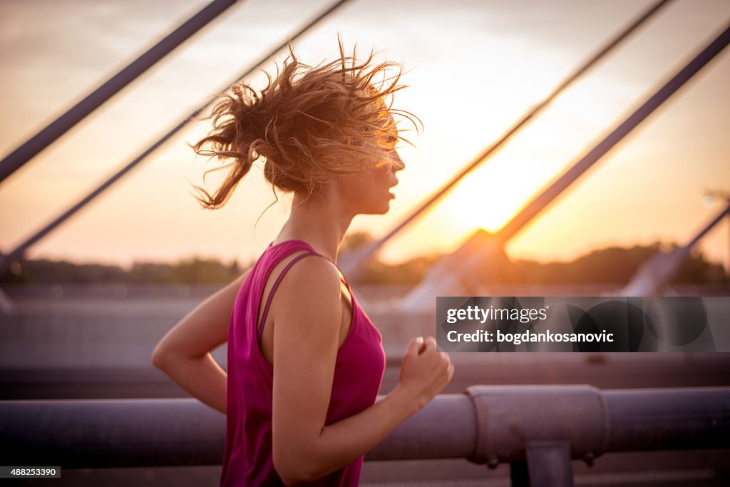 Sportlerin Laufen auf Brücke am Morgen