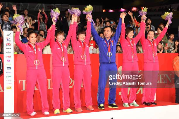 Shiwen Liu, Yuling Zhu, Meng Chen, Coach Linghui Kong, Ning Ding and Xiaoxia Li of team China pose with gold medal during day eight of the 2014 World...