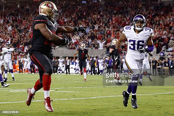 Carlos Hyde of the San Francisco 49ers points at Robert Blanton of the Minnesota Vikings as he runs for a touchdown during their NFL game at Levi's...