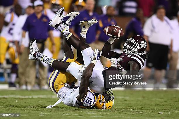 De'Runnya Wilson of the Mississippi State Bulldogs is brought down by Tre'Davious White of the LSU Tigers during a game at Davis Wade Stadium on...