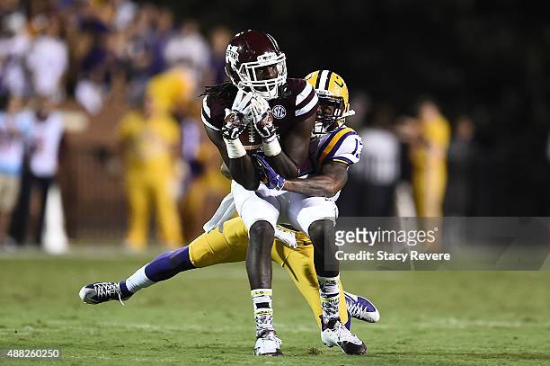 De'Runnya Wilson of the Mississippi State Bulldogs is brought down by Dwayne Thomas of the LSU Tigers during a game at Davis Wade Stadium on...