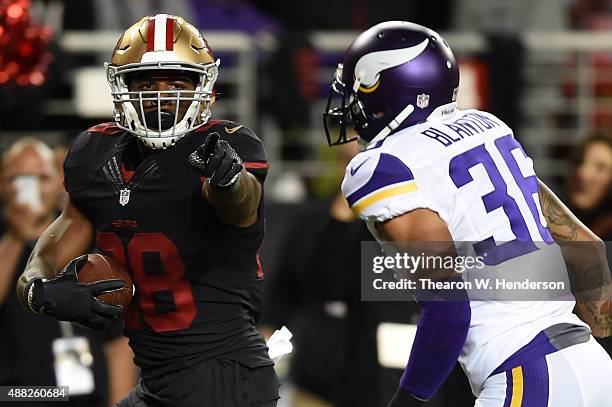 Carlos Hyde of the San Francisco 49ers points at Robert Blanton of the Minnesota Vikings as he runs for a touchdown during their NFL game at Levi's...