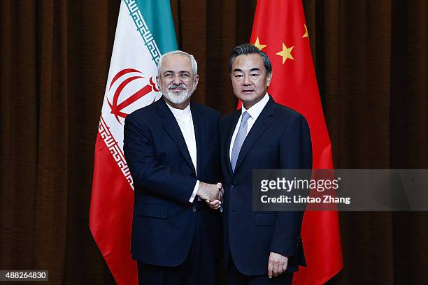 China's Foreign Minister Wang Yi shakes hands with Iranian Foreign Minister Javad Zarif before a bilateral meeting on September 15, 2015 in Beijing,...