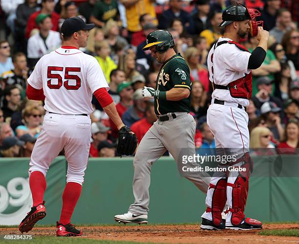 Boston Red Sox relief pitcher Chris Capuano came in the ninth inning. Oakland Athletics second baseman Nick Punto pictured, scores on a deep line...