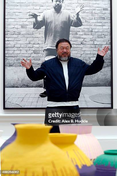 Ai Weiwei stands with his sculpture 'Coloured Vases' as he previews works from His landmark art exhibition at the Royal Academy of Arts on September...