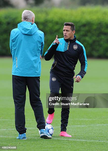 Arsenal manager Arsene Wenger talks to Alexis Sanchez during a training session at London Colney on September 15, 2015 in St Albans, England.